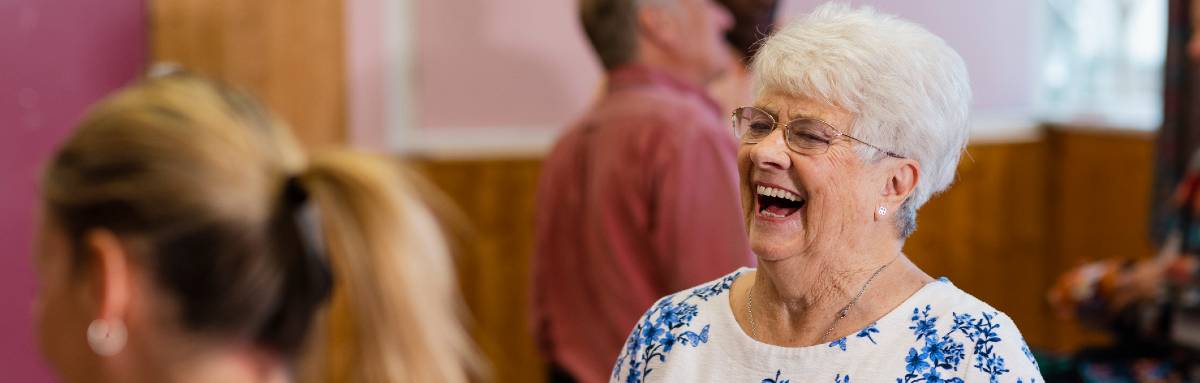 A woman laughs while attending a Silver Sunday event